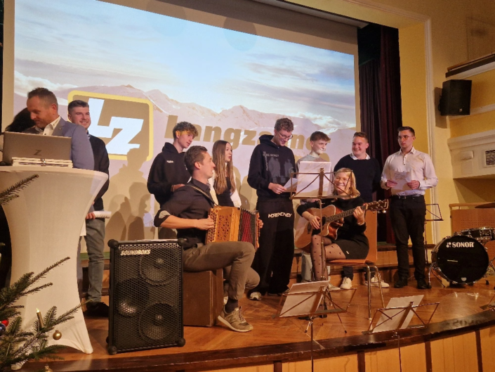 langzauner-weihnachtstradition Mutprobe für neue Mitarbeiter, die ein Weihnachtslied vortragen